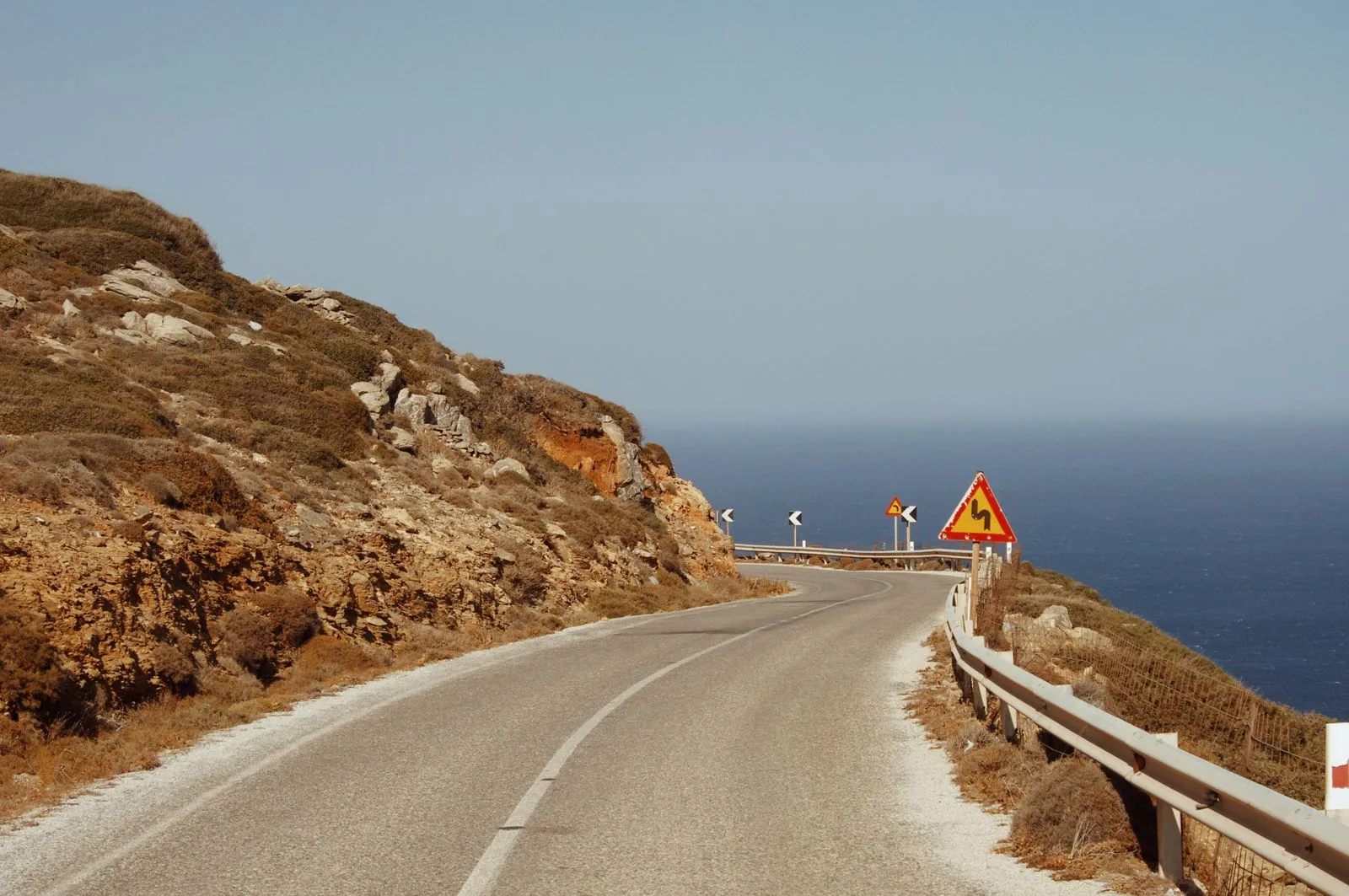 A scenic coastal road with views of the sea, similar to the roads through the Vasilikos peninsula