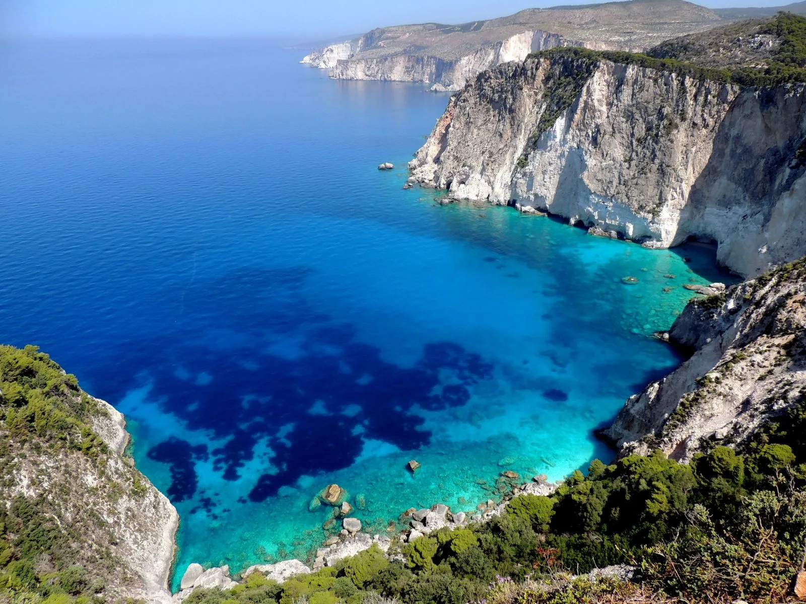 Dramatic cliffs and azure sea near Keri, Zakynthos, with views toward the Mizithres