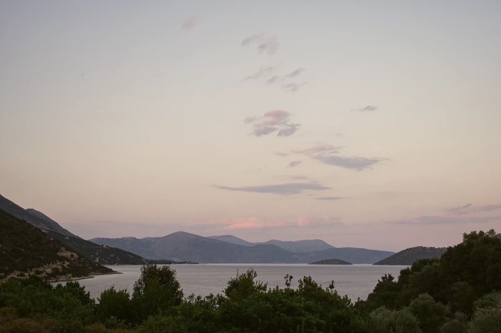 A tranquil sunset over the Greek sea and coastline, similar to sunset at Porto Limnionas, Zakynthos